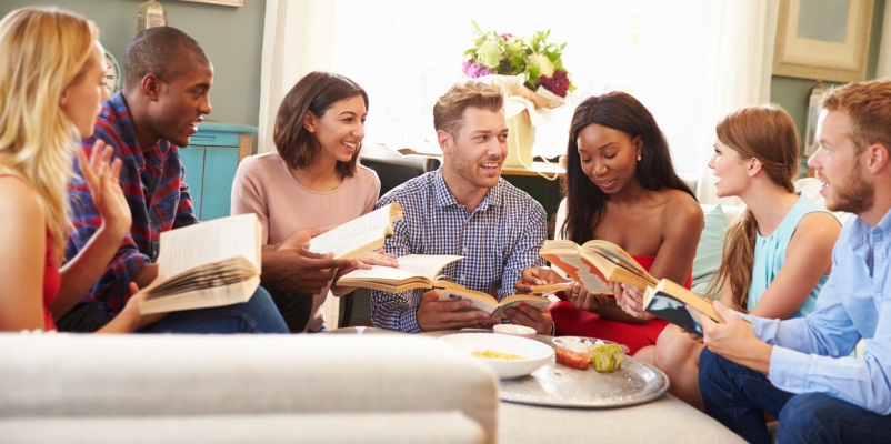 Group Of Friends Taking Part In Book Club At Home